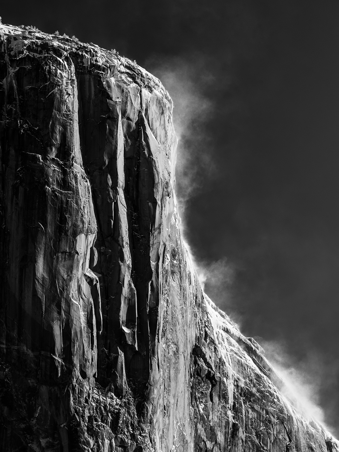 Black and white photo of snowdrifts blowing off of El Capitan in Yosemite National Park